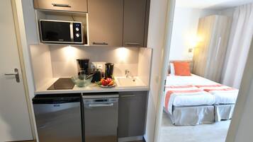 A compact kitchenette with a microwave, coffee maker, and a small sink.