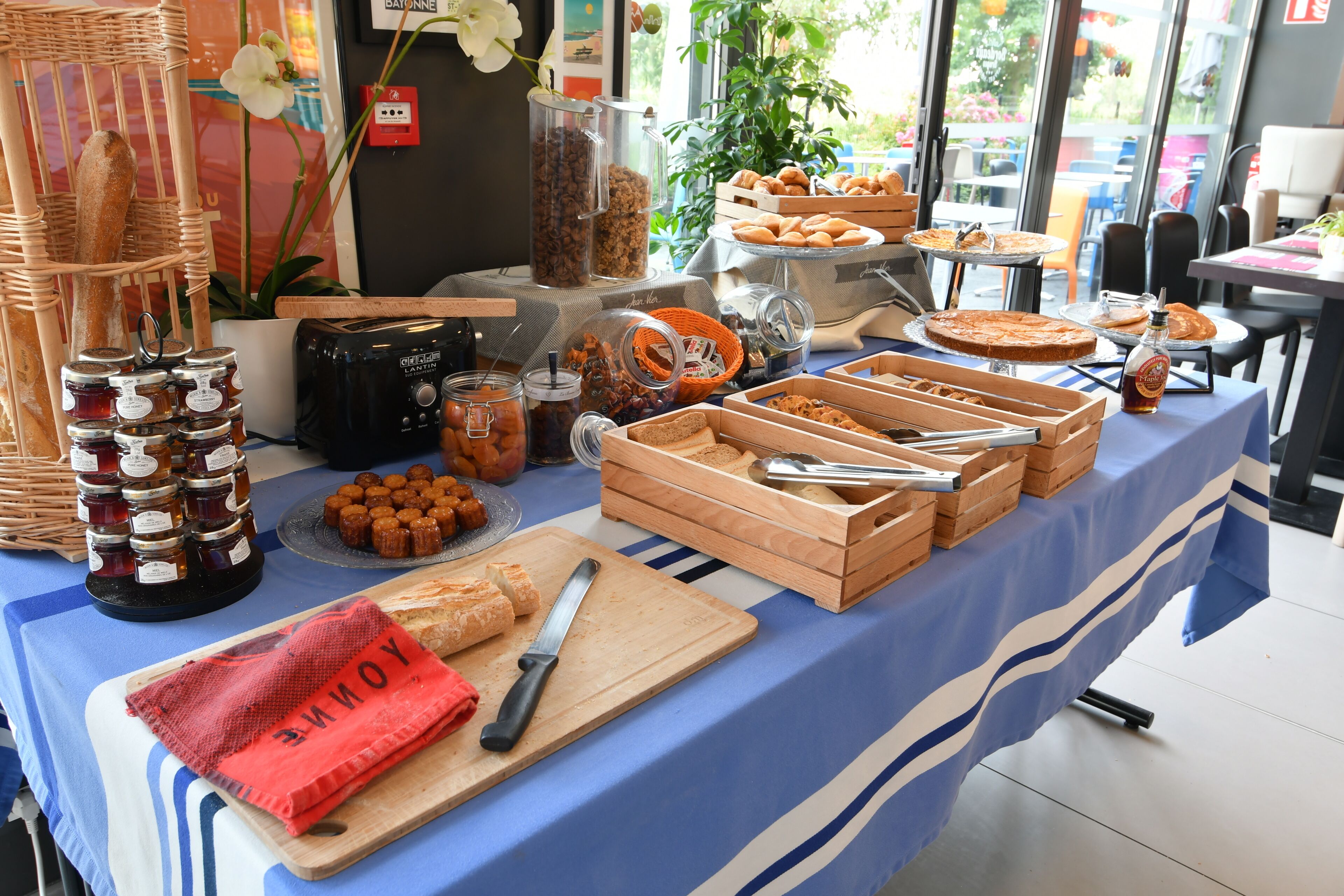 A buffet table with various food items, including bread, pastries, and condiments.