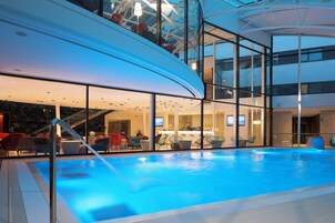 Una piscina techada, sillones reclinables de piscina