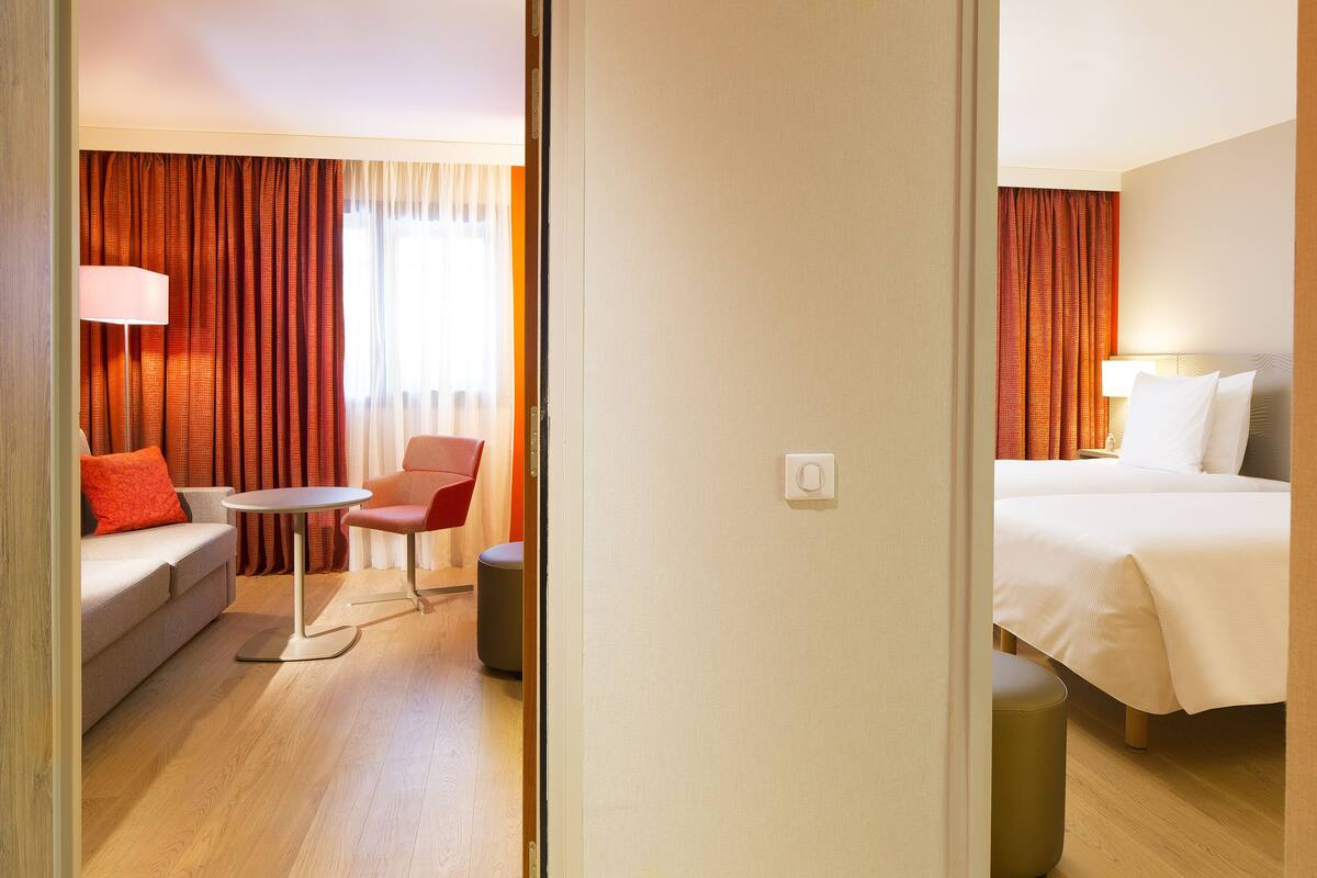 Una habitación de hotel con una cama, un sofá, una mesa y una silla.