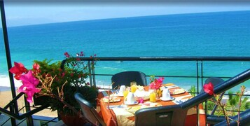 Una mesa lista para el desayuno con vista al océano.