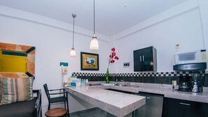 Een moderne keuken met een marmeren aanrecht, zwarte kasten en een ingebouwde magnetron.