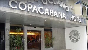 L’extérieur de l’hôtel Copacabana se distingue par une grande enseigne, une entrée en verre et un élément décoratif sur le mur.