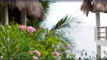 A tropical resort with thatched-roof structures and lush greenery.