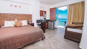 A hotel room with a large bed, a kitchenette, a balcony with a view, and a small dining area. - Hotel Boutique Suites Nadia Bucerias (Bucerías)