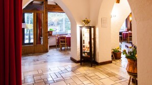 A corridor with tiled flooring, wooden beams, and arched ceilings. - Hotel Mille Pini (Scanno)