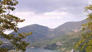 Un lago circondato da montagne, con alberi sullo sfondo.