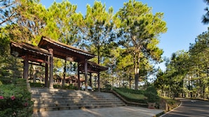 A traditional wooden pavilion with steps leading up to it, surrounded by lush greenery and tall trees. - Sam Tuyen Lam Resort (Xuan Huong - Da Lat)