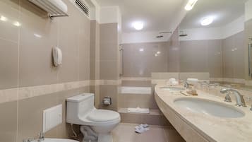 A modern bathroom with a toilet, bidet, sink, and shower.