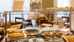 A buffet with various desserts and pastries, including pies, cakes, and pastries, arranged on a glass table. - Hotel Pace (Torri del Benaco)