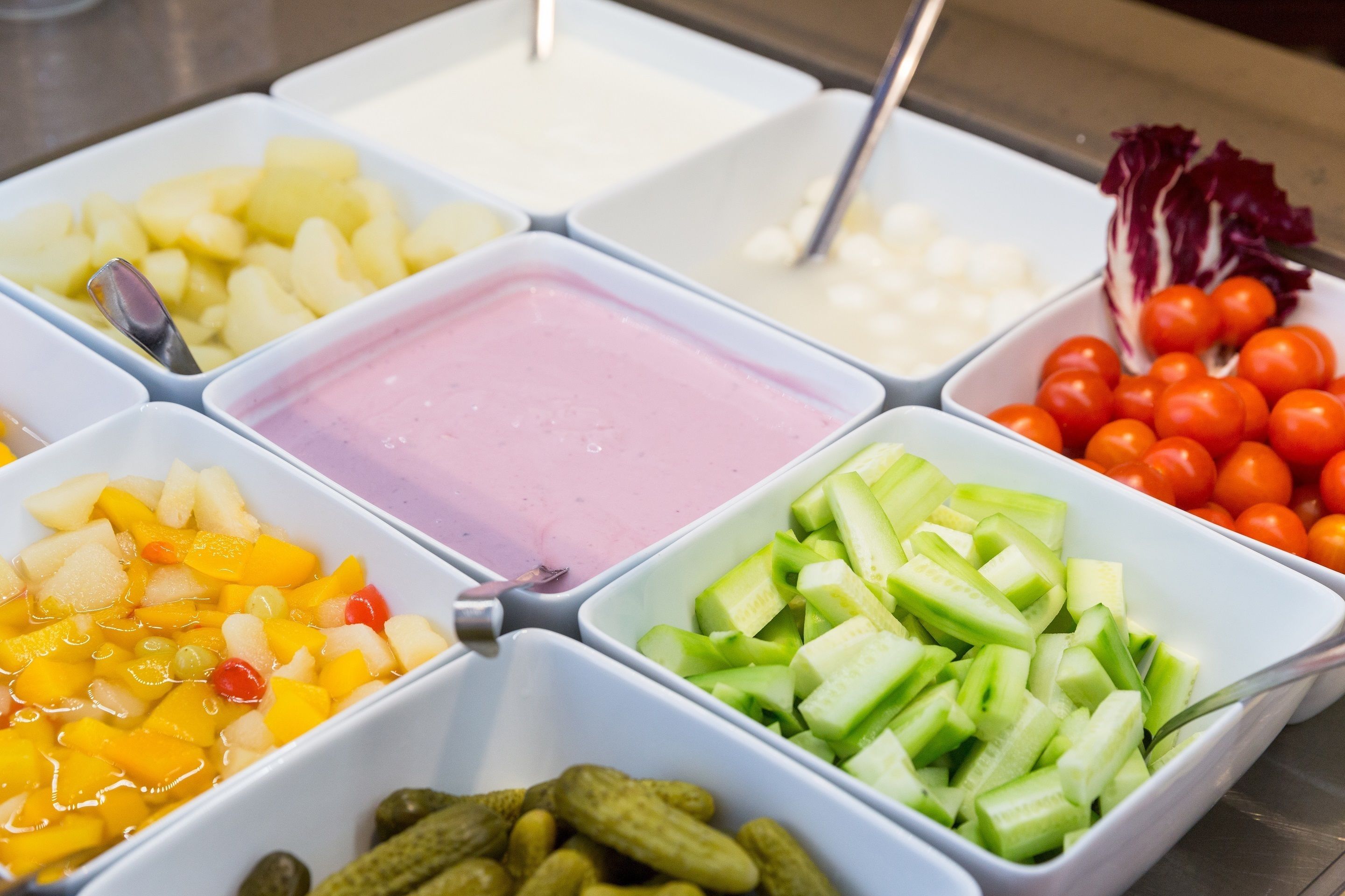 A buffet with various food items in separate containers.
