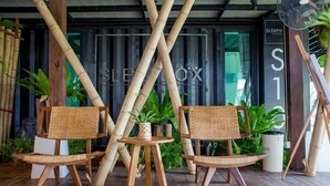 A modern interior with bamboo furniture and a sign reading "SLEEPBOX". - Sleepbox Chiangmai Hotel (Chiang Mai)