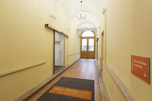 A hotel hallway with a sign indicating the door to open. - easyHotel Budapest Oktogon (Budapest)