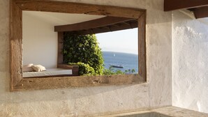 Un baño con un espejo grande, un mostrador de madera y vistas al mar.