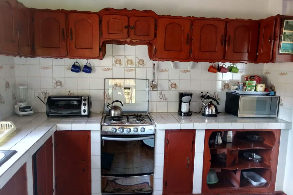 A kitchen with wooden cabinets, a gas stove, a microwave, and a toaster.