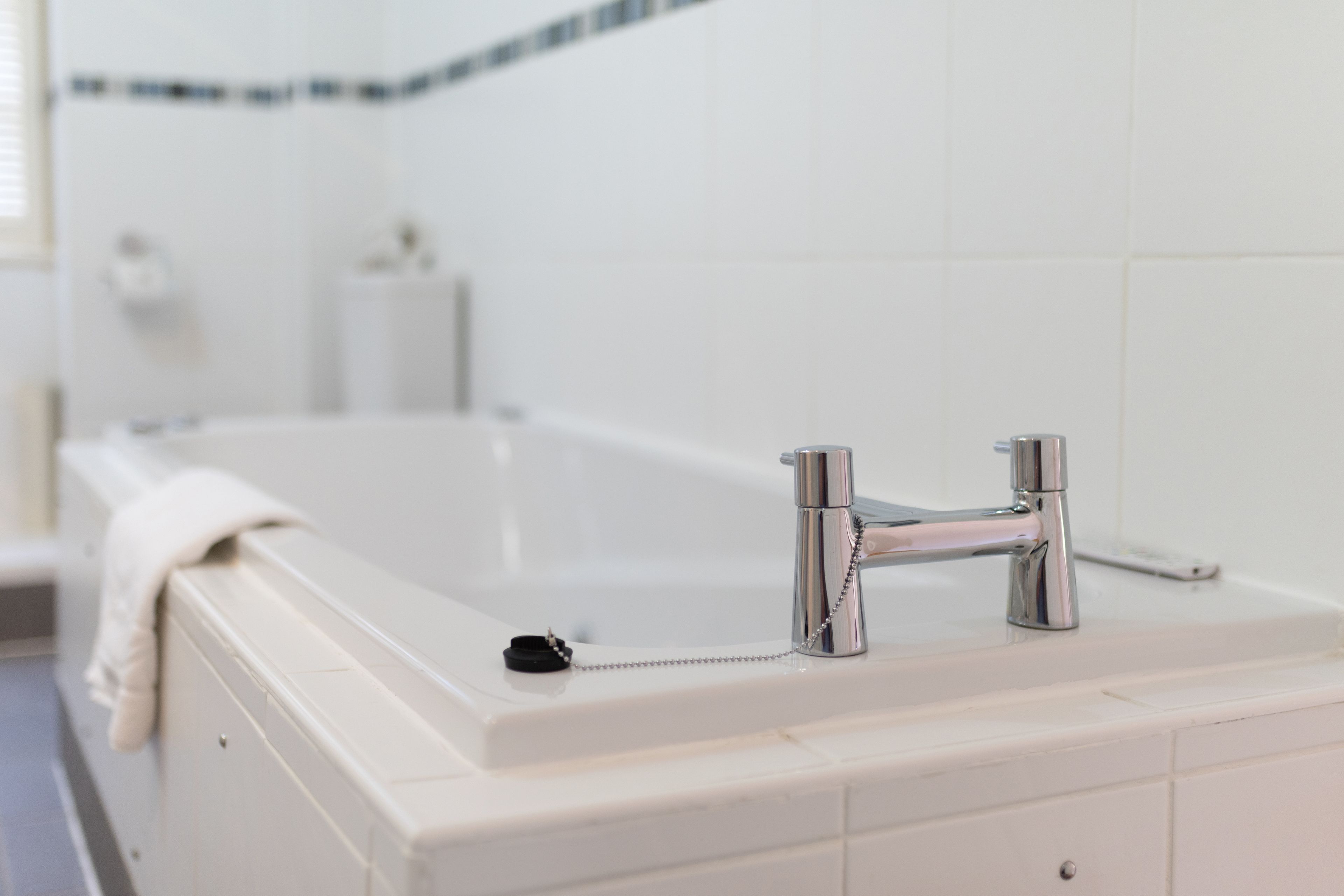 A bathroom with a bathtub, a sink, and a towel rack.