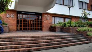 A building with a brick facade and a set of steps leading to a door marked "REAL 85". - Suites Real 85 (Bogota)