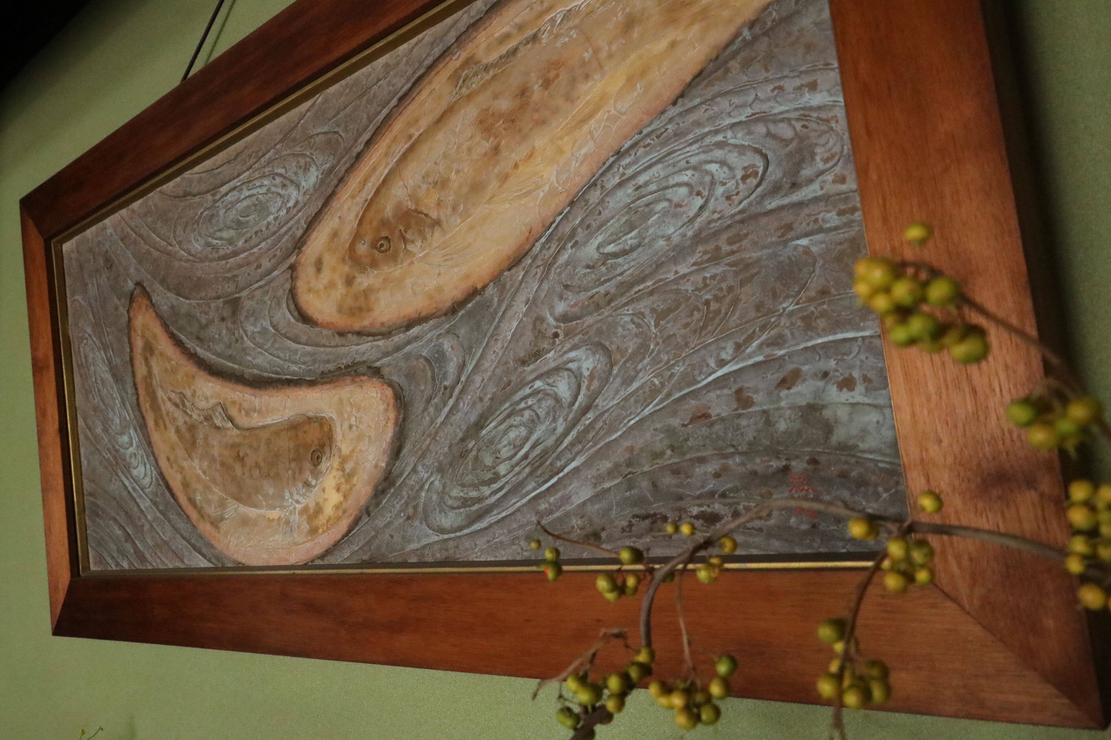 A framed artwork with abstract designs and a wooden frame.