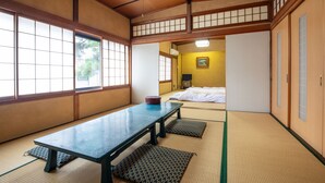 A traditional Japanese room with tatami flooring, a low table, and sliding doors. - Daibutsu Ryokan (Takaoka)