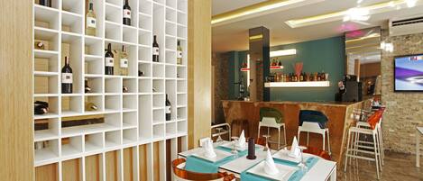 A modern restaurant with white and wooden decor, a bar area, and a TV screen.