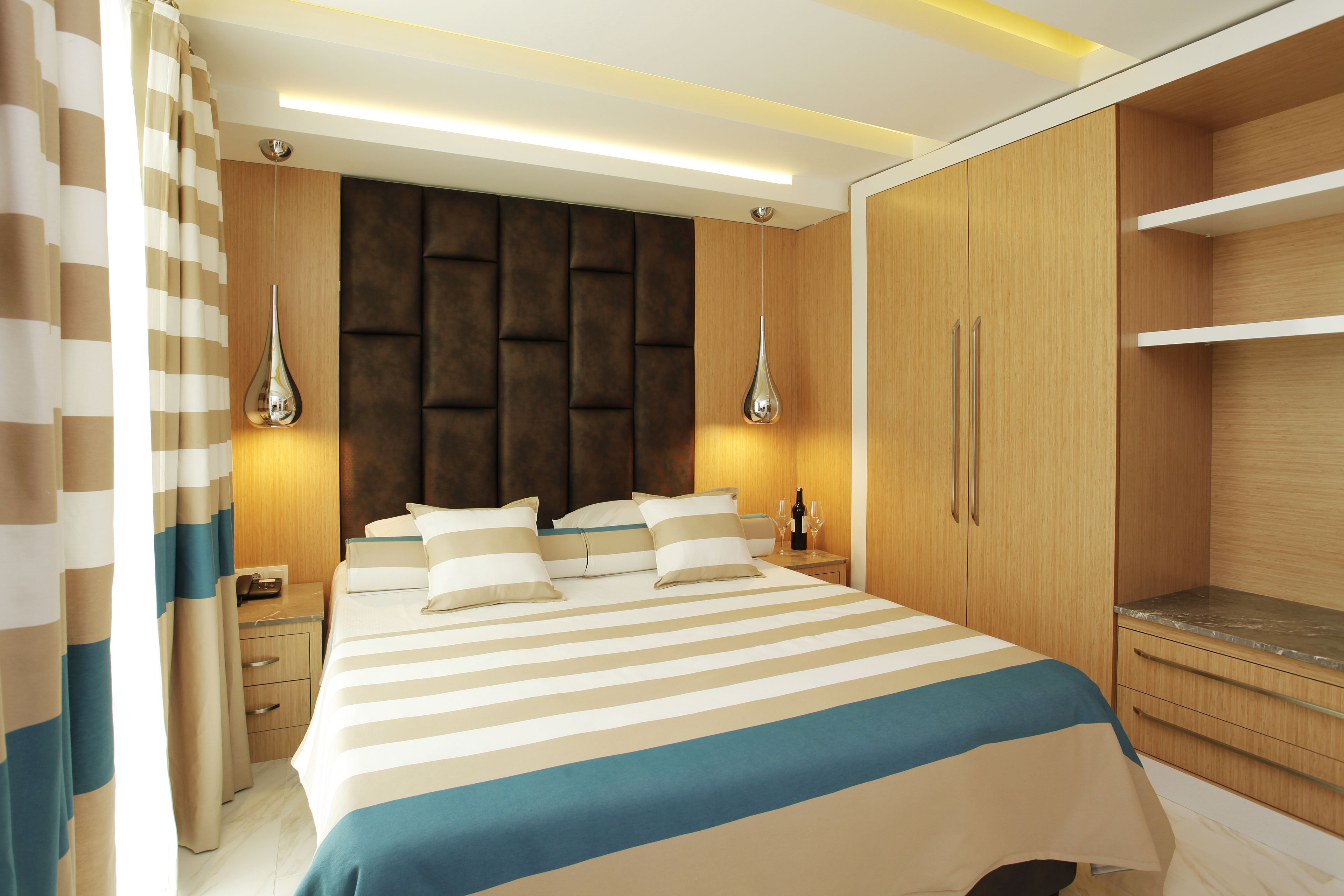 Un dormitorio moderno con una cama grande, un armario de madera y lámparas de noche.