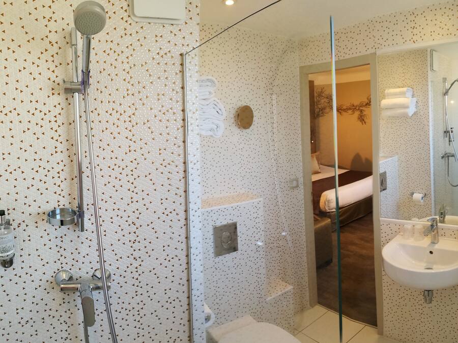 Un baño moderno con ducha, inodoro y lavamanos.