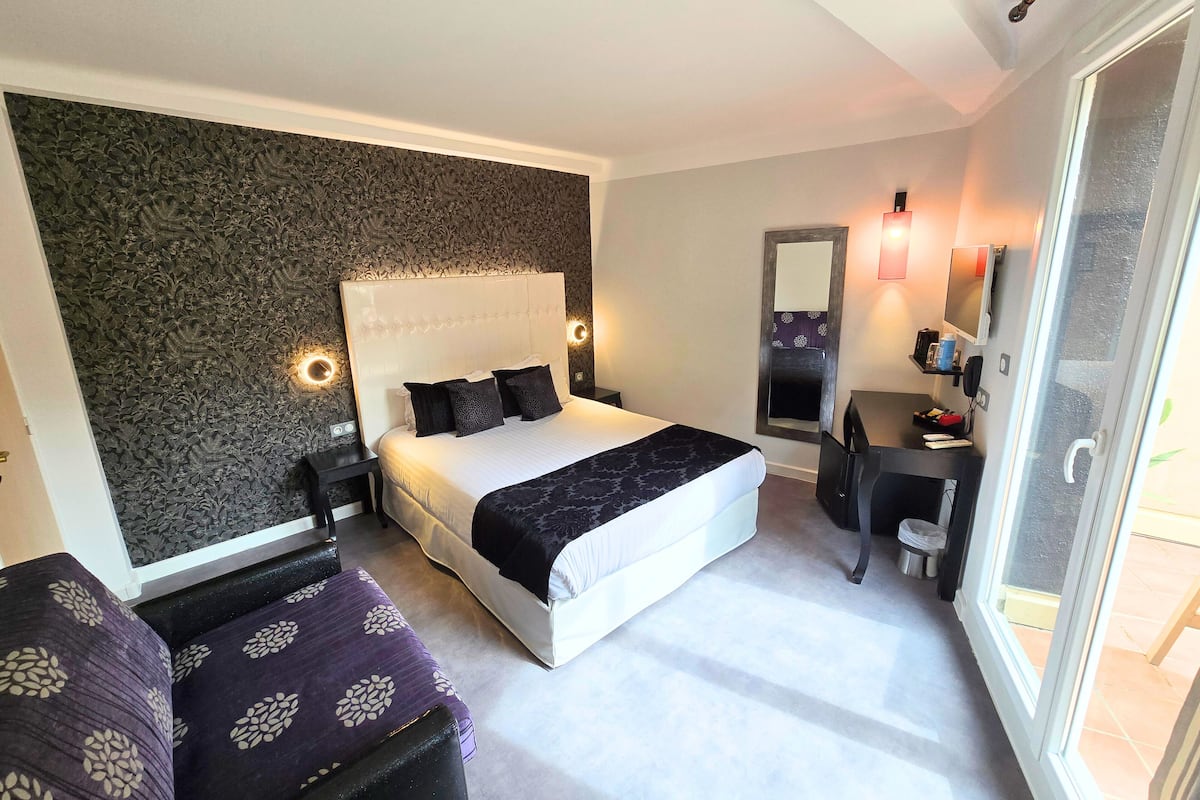 Moderni hotellihuone, jossa on suuri sänky, työpöytä ja tuoli.