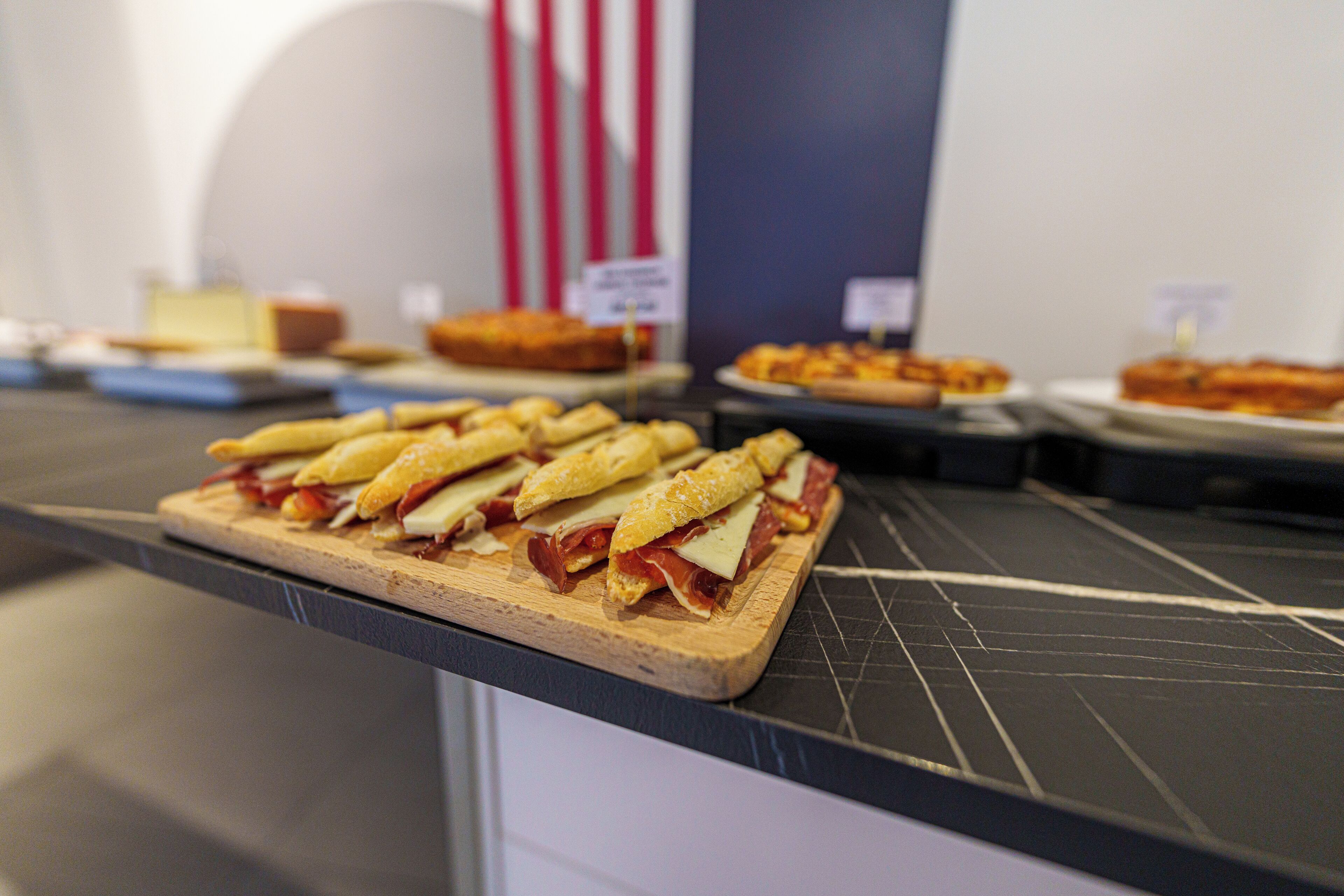 A buffet with various dishes, including sandwiches and desserts.