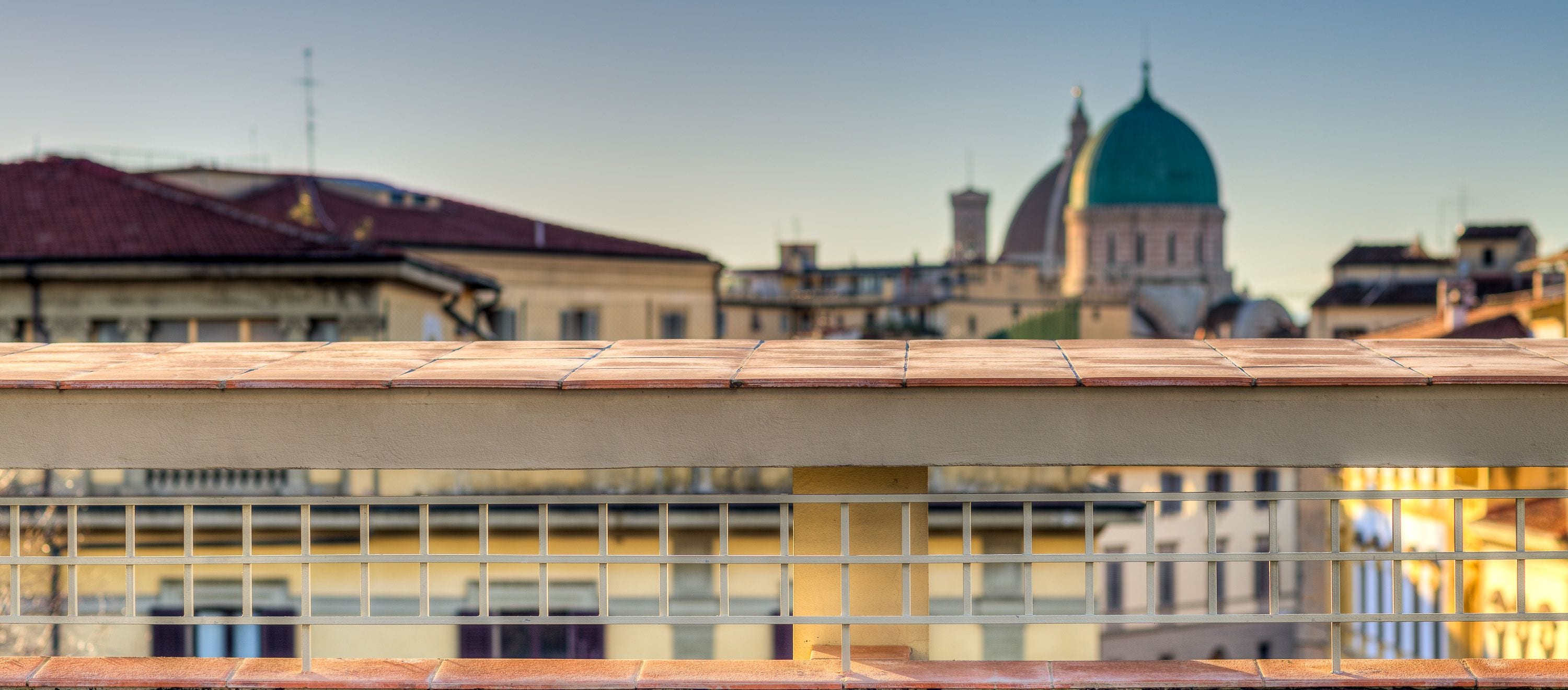 A building with a tiled roof and a balcony railing.