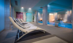 A spa area with sun loungers, a pool, and a massage room.