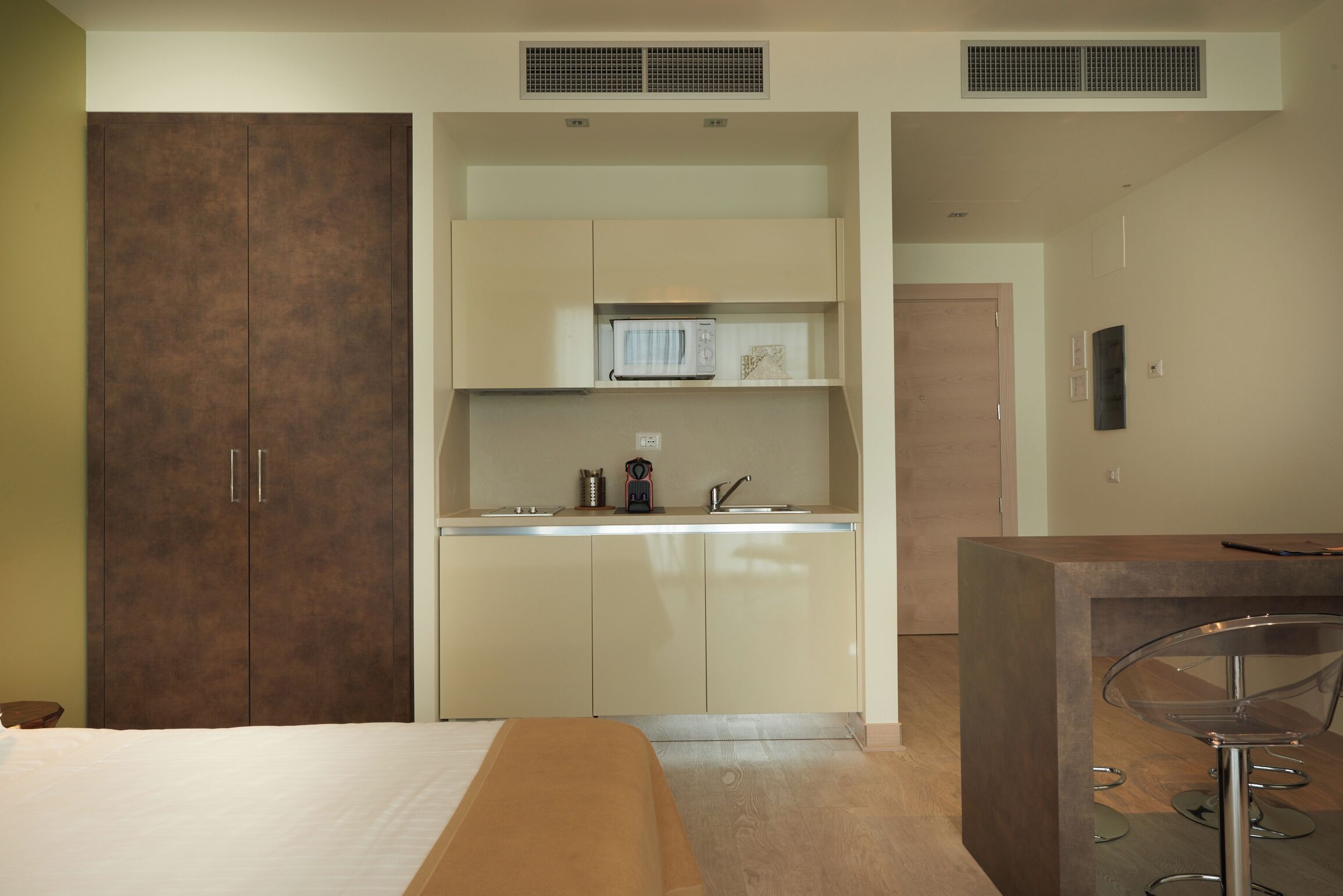 Una cocina moderna con microondas, pileta y alacenas.