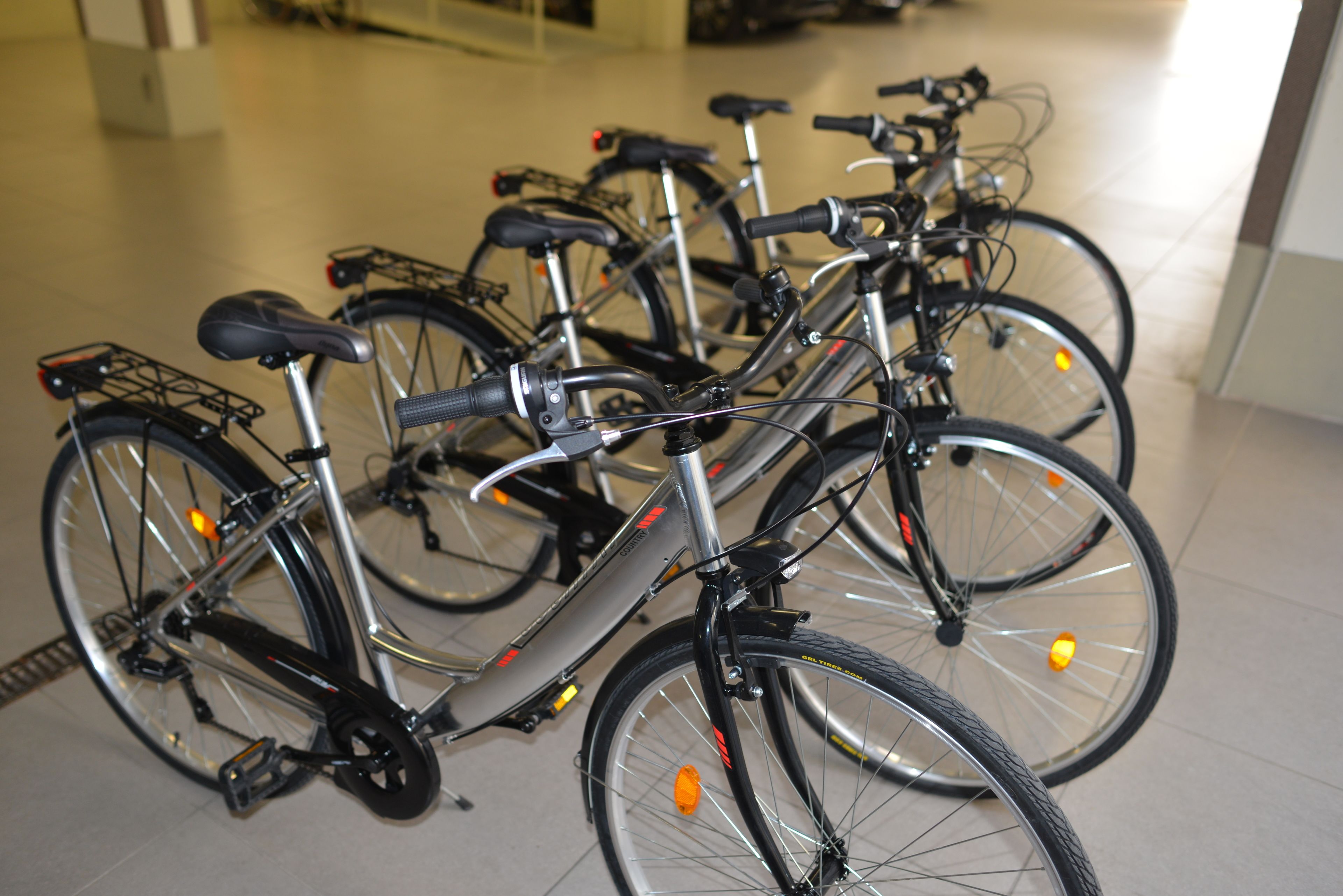 A row of bicycles parked indoors, likely in a public or commercial space.