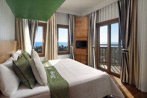 A hotel room with a bed, a TV, and a balcony with a view. - Selectum Family Resort Belek (Serik)