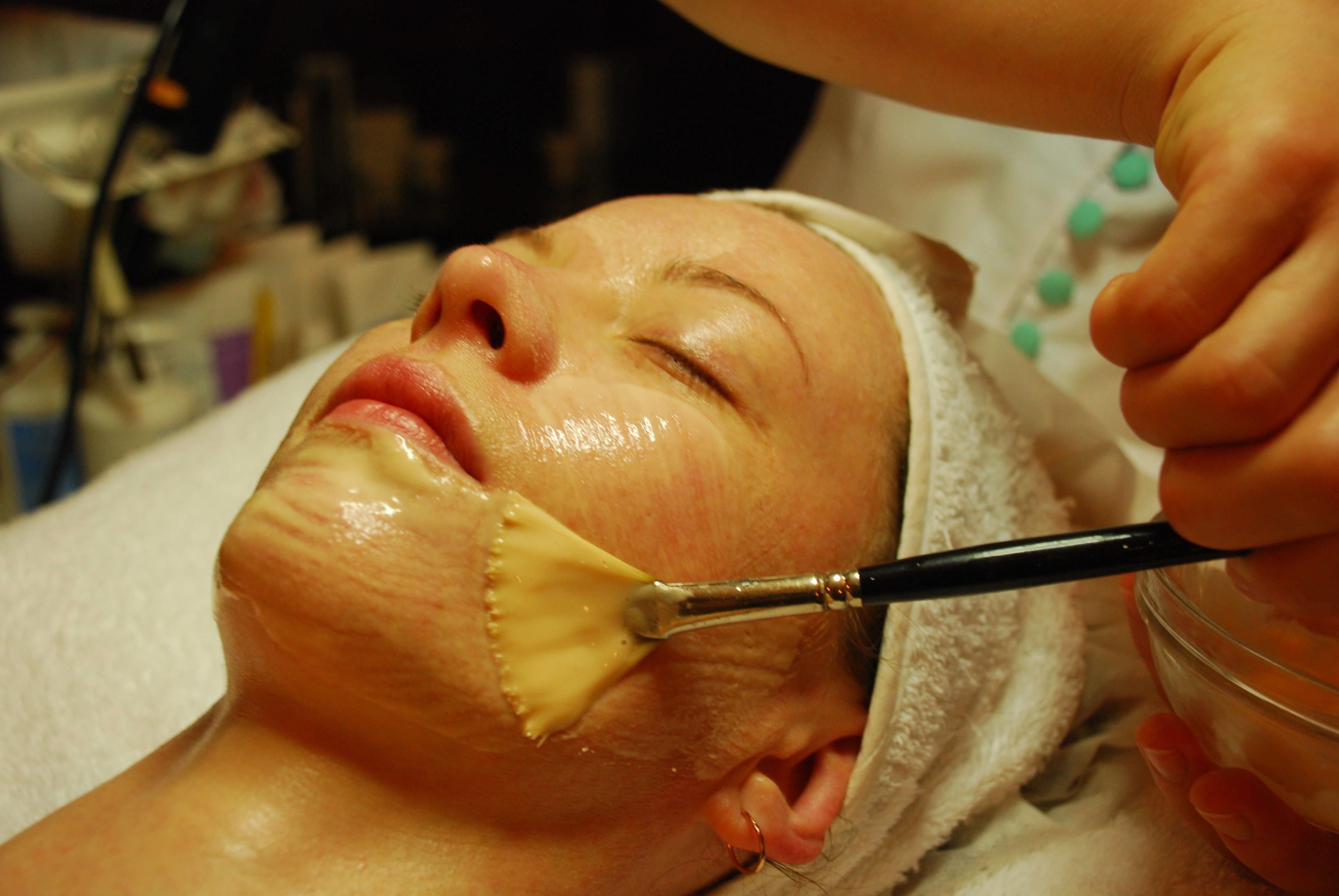 Uma pessoa recebendo um tratamento facial com um pincel.
