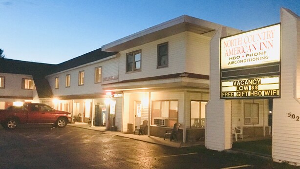 Et North Country Inn med et skilt, der annoncerer faciliteter som HBO, telefon, aircondition og gratis WiFi.