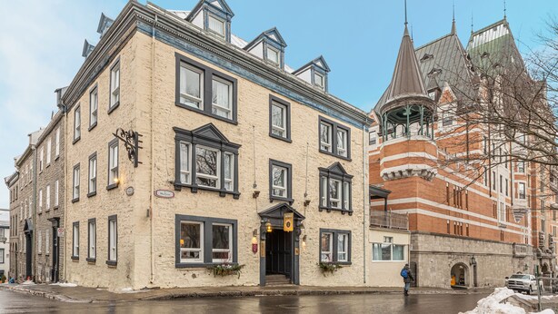 A historic building with a prominent tower and a traditional facade. - Hôtel Jardin Du Gouverneur (Québec City)