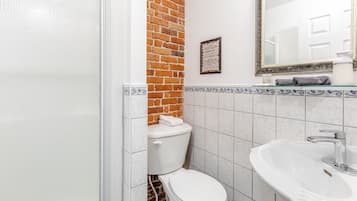 A bathroom with a white toilet, a sink, and a mirror.