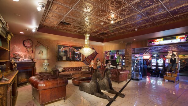 A spacious lobby with leather sofas, a large chandelier, and a casino gaming area. - Prospector Hotel & Gambling Hall (Ely)