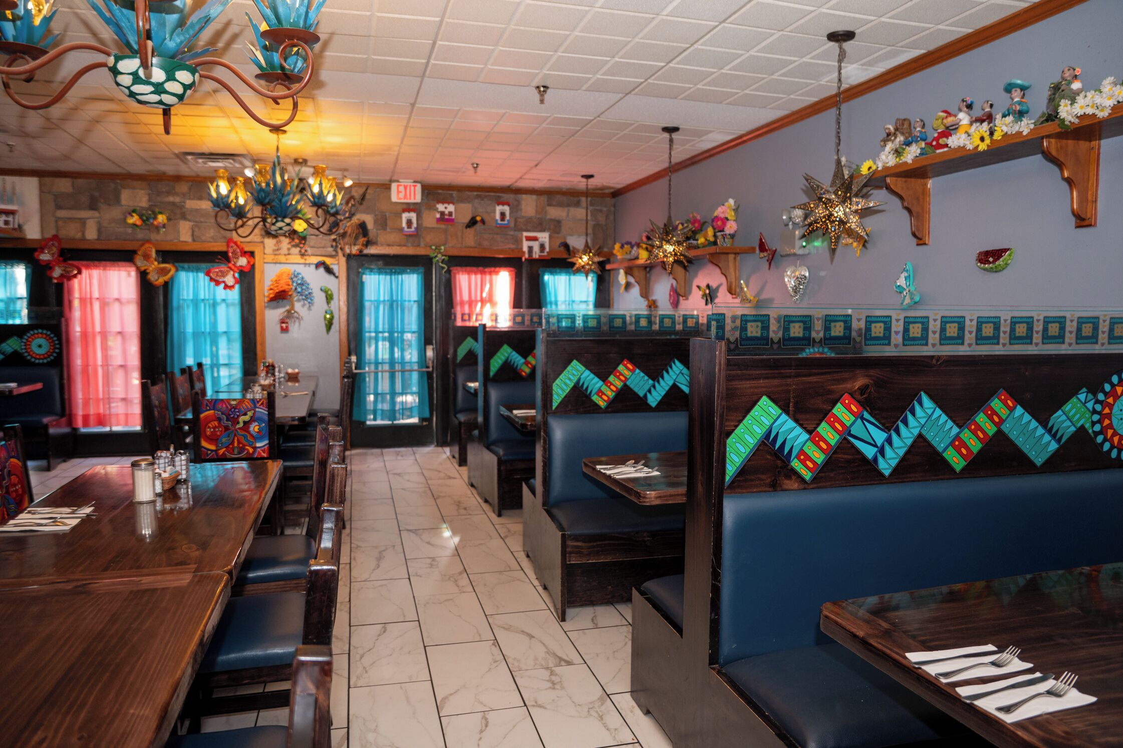 A restaurant interior with booths, tables, and a tiled floor.