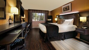 A hotel room with a bed, desk, and TV. - Prospector Hotel & Gambling Hall (Ely)