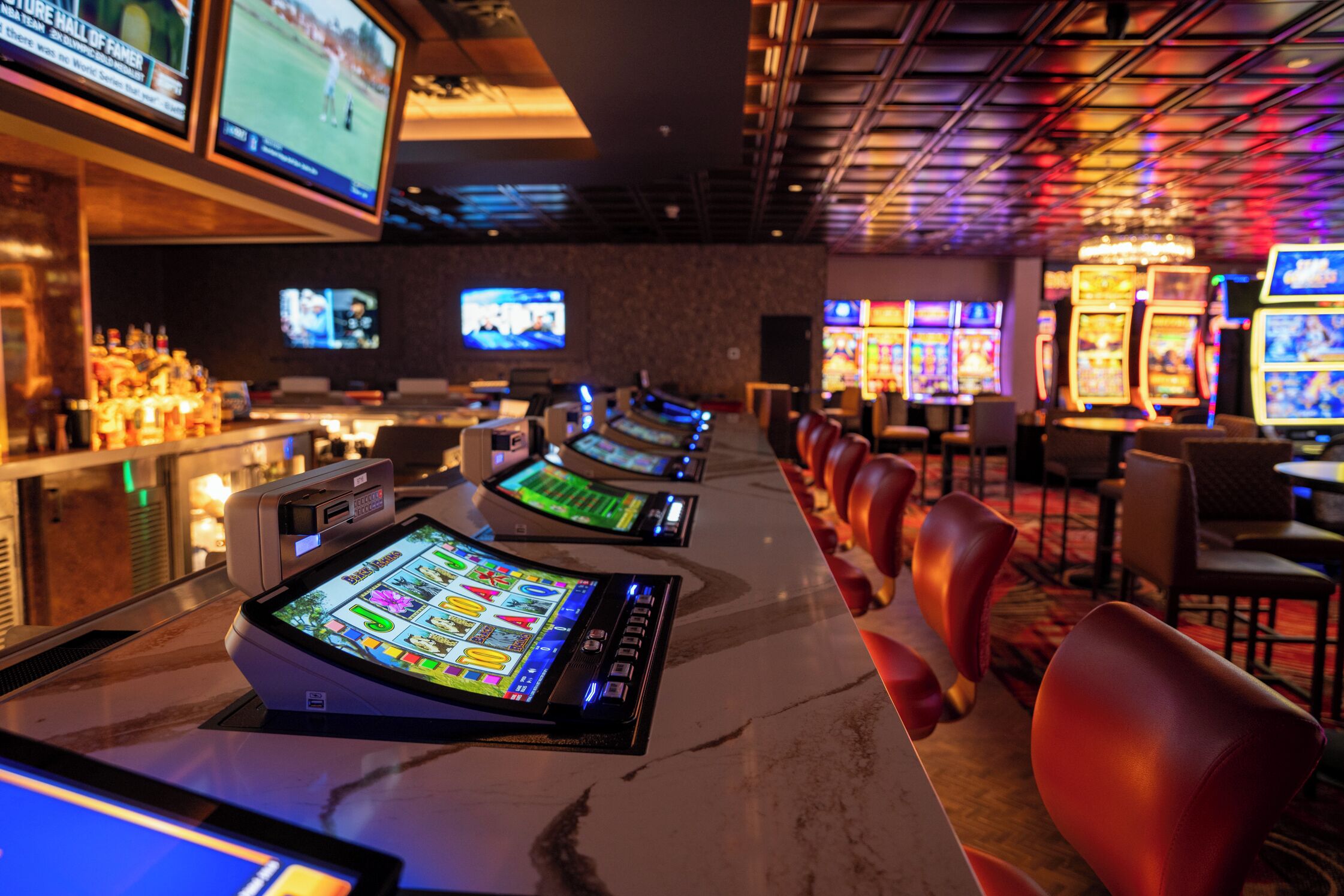 Un casino con máquinas tragamonedas y una zona de bar.