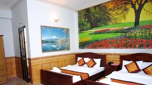 A hotel room with two wooden beds, a painting of a mountain landscape, and a painting of a garden with a tree. - Thanh Hong Hotel (Ho Chi Minh City)
