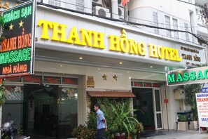 Ein Hotel mit einem auffälligen, gelben Schild, auf dem "THANH HÒNG HOTEL" steht.