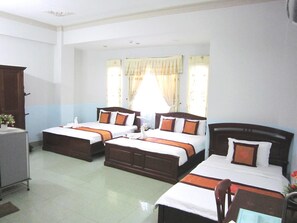 A hotel room with three beds, a desk, and a window with curtains. - Thanh Hong Hotel (Ho Chi Minh City)