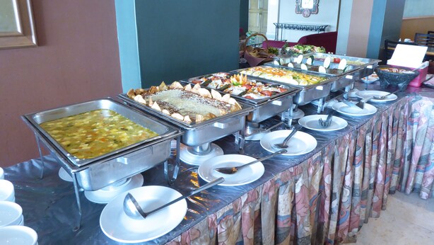 A buffet setup with various food stations and dining utensils.