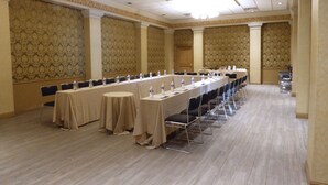 A conference room with a long table, chairs, and water bottles.