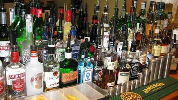 A bar with various bottles of alcohol, including vodka, whiskey, and other spirits.