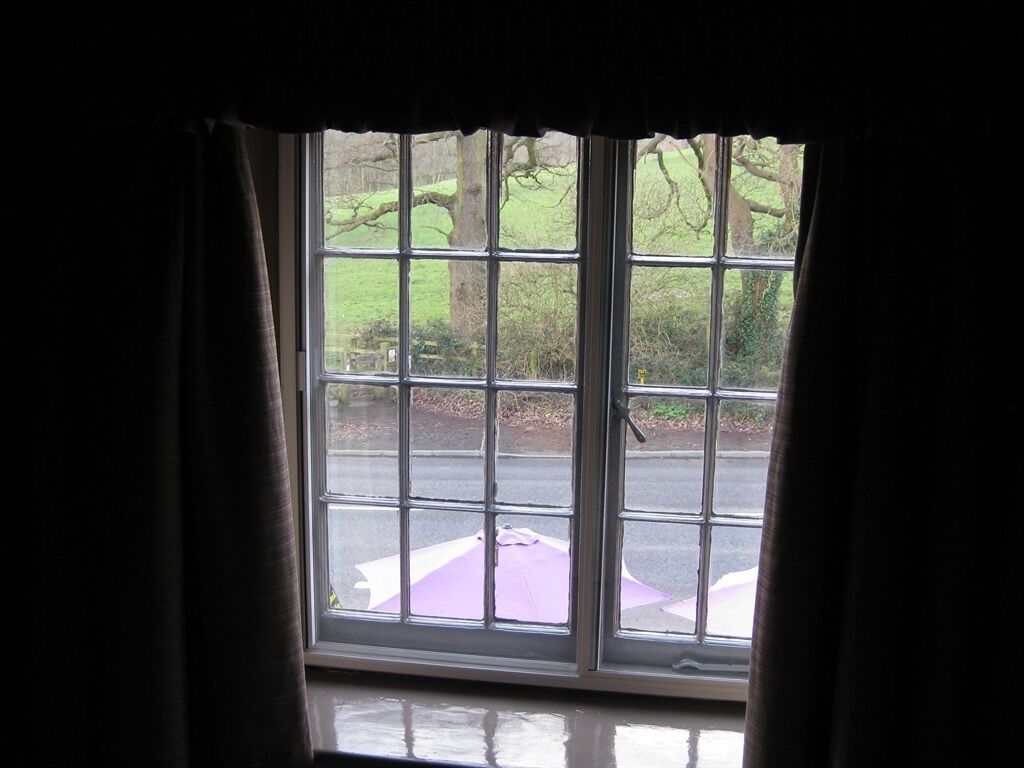 Ein Fenster mit Blick auf eine Straße und grüne Umgebung.