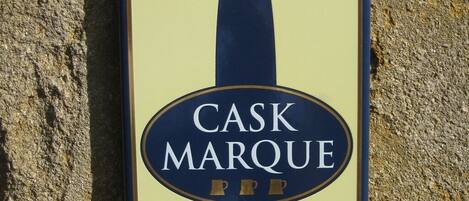 A sign with the text "CASK MARQUE" and three small gold symbols.