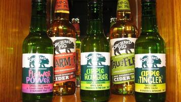A selection of Orchard Pig cider bottles on a wooden shelf.